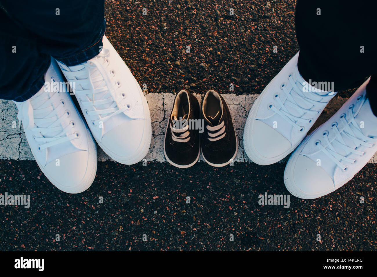 Hommes et femmes recadrée jambes wearing white sneakers sneakers sont entre eux pour leur enfant Banque D'Images