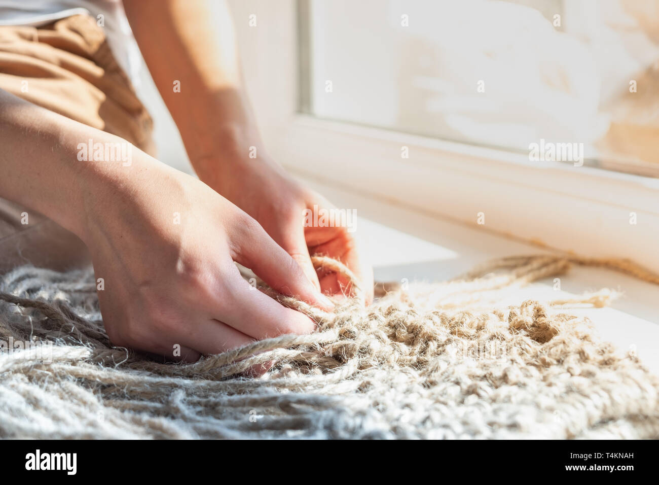 Faire un autre sac de chanvre. Un tricot mains femme acessory hors de jute naturelle corde, close-up view et high-key light Banque D'Images