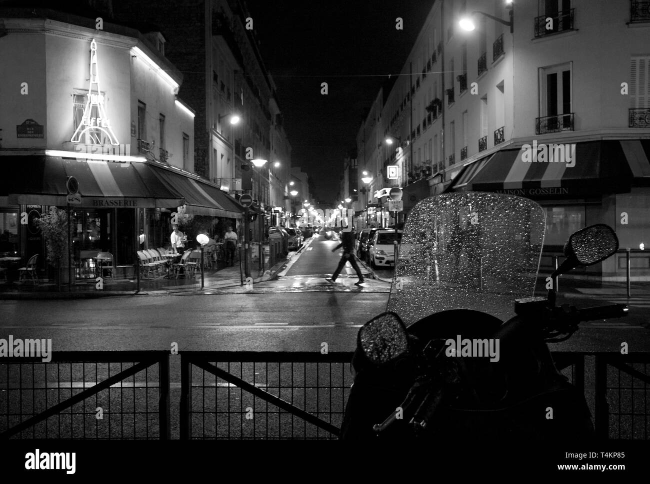 Rue illuminé des pluies à paris avec une tour eiffel en néon et de gouttes de pluie sur le pare-brise de moto Banque D'Images