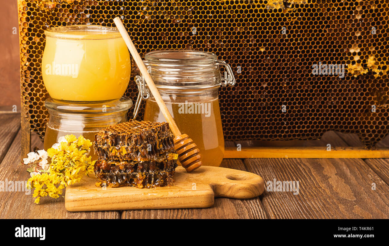 Miel parfumé frais dans un bocal en verre sur un fond de bois sur la table. Différents types de miel d'abeilles. Produits naturels. Banque D'Images