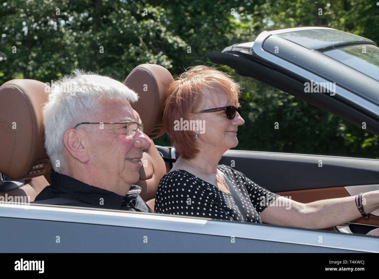 Heureux couple plus âgé avec une voiture décapotable de luxe Banque D'Images