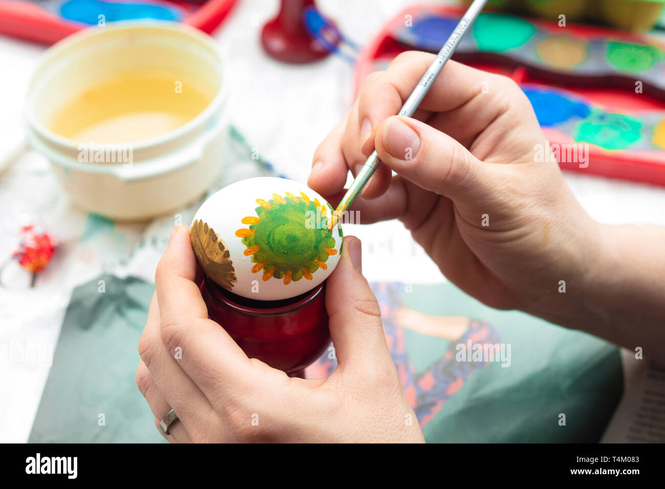 Détail de la peinture femme un oeuf de Pâques avec le pinceau et l'aquarelle. Banque D'Images