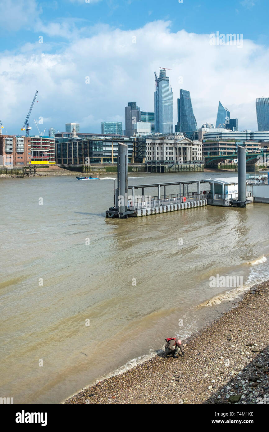 Un homme mudlarking à marée basse sur la rive de la Tamise à Londres. Banque D'Images