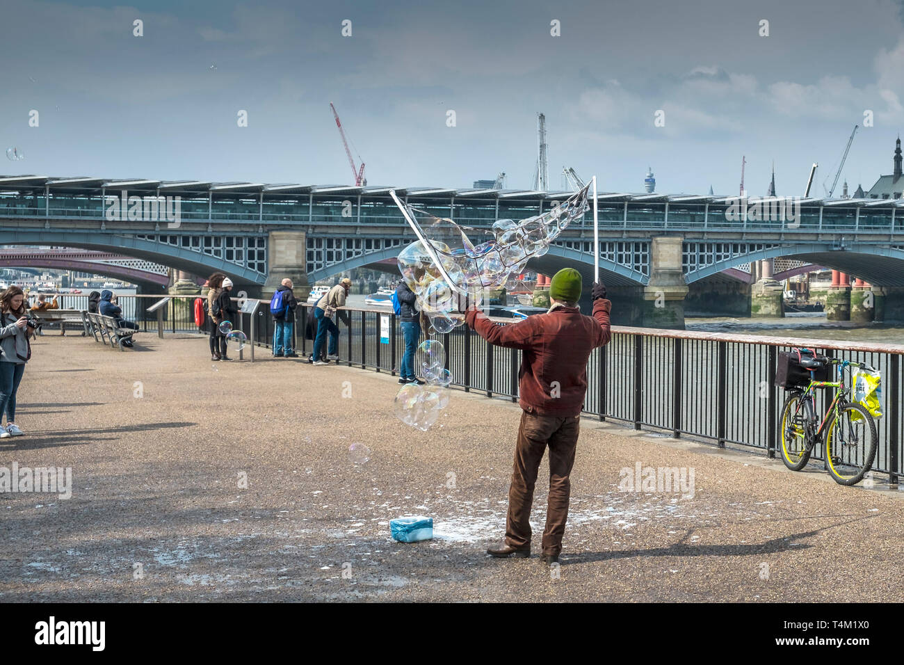 Un musicien ambulant création de bulles sur la rive sud de Londres. Banque D'Images