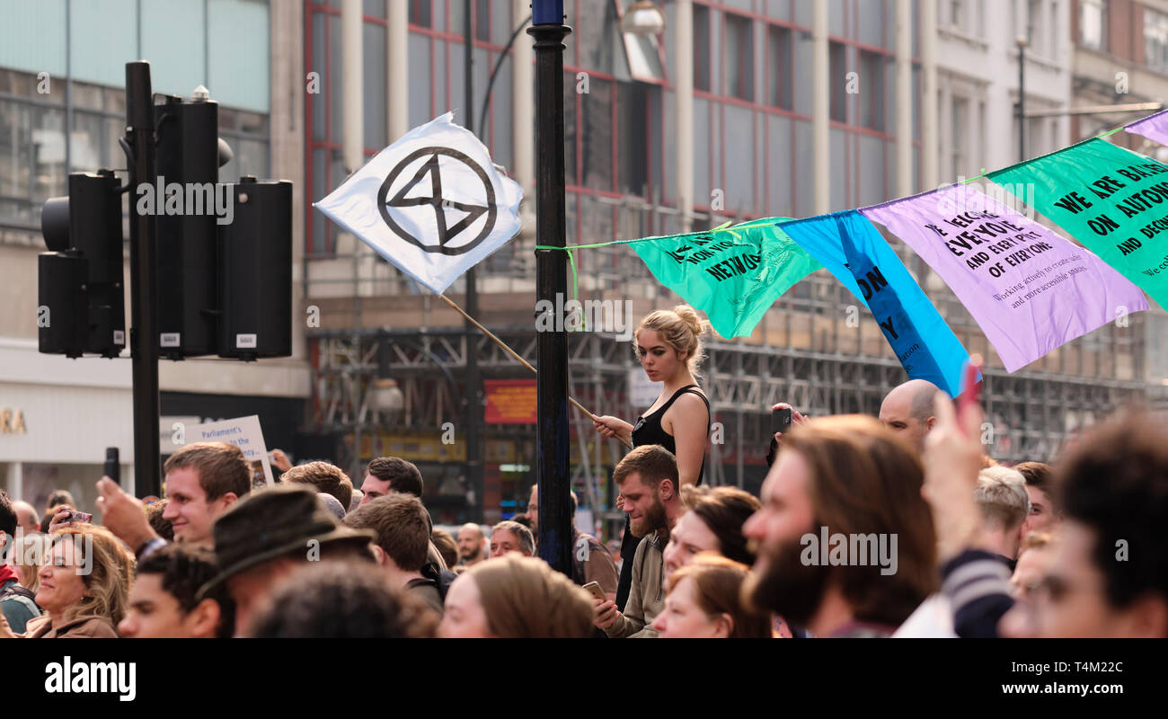 London, UK 17 avr, 2019.. Les manifestants agitent des drapeaux et bannières en attente à l'extérieur de Oxford Circus, troisième jour de l'extinction de rébellion dans l'arrêt London traffic Banque D'Images