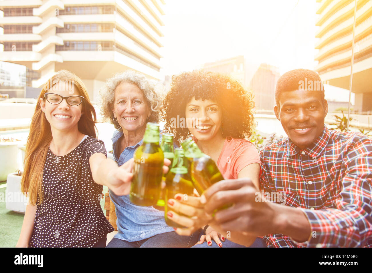 Friends toasting at a party avec une bouteille de bière Banque D'Images