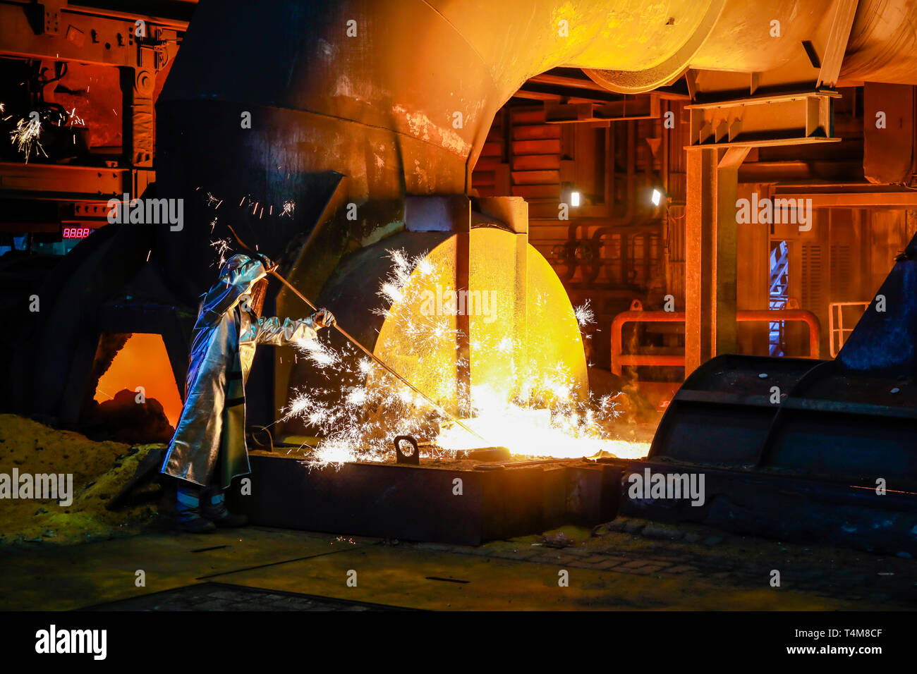 Duisburg, Ruhr, Rhénanie du Nord-Westphalie, Allemagne - ThyssenKrupp Steel, un travailleur de l'acier dans un vêtement de protection prend un degré de fonte de 1500 chaude échantillon Banque D'Images