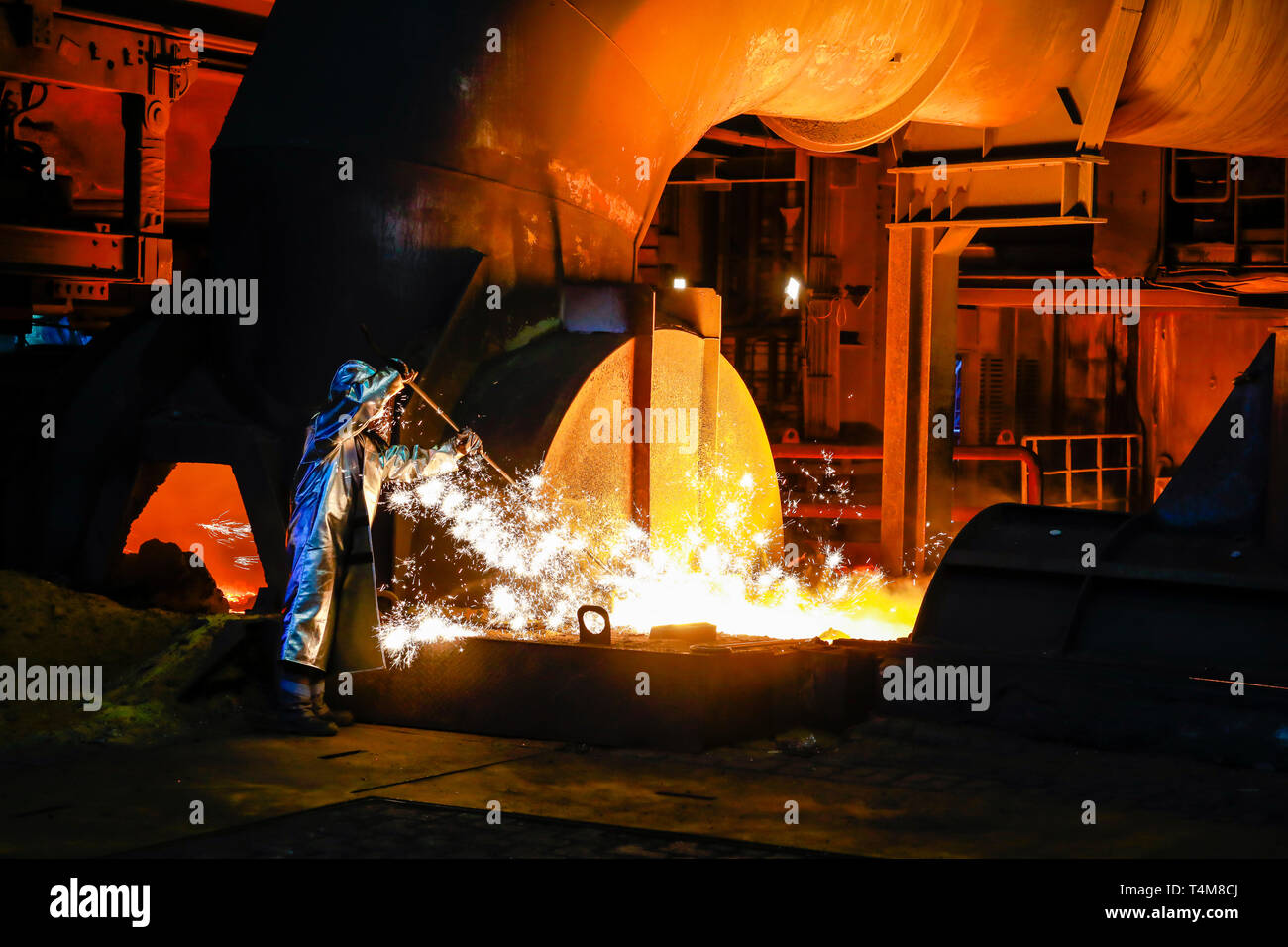 Duisburg, Ruhr, Rhénanie du Nord-Westphalie, Allemagne - ThyssenKrupp Steel, un travailleur de l'acier dans un vêtement de protection prend un degré de fonte de 1500 chaude échantillon Banque D'Images
