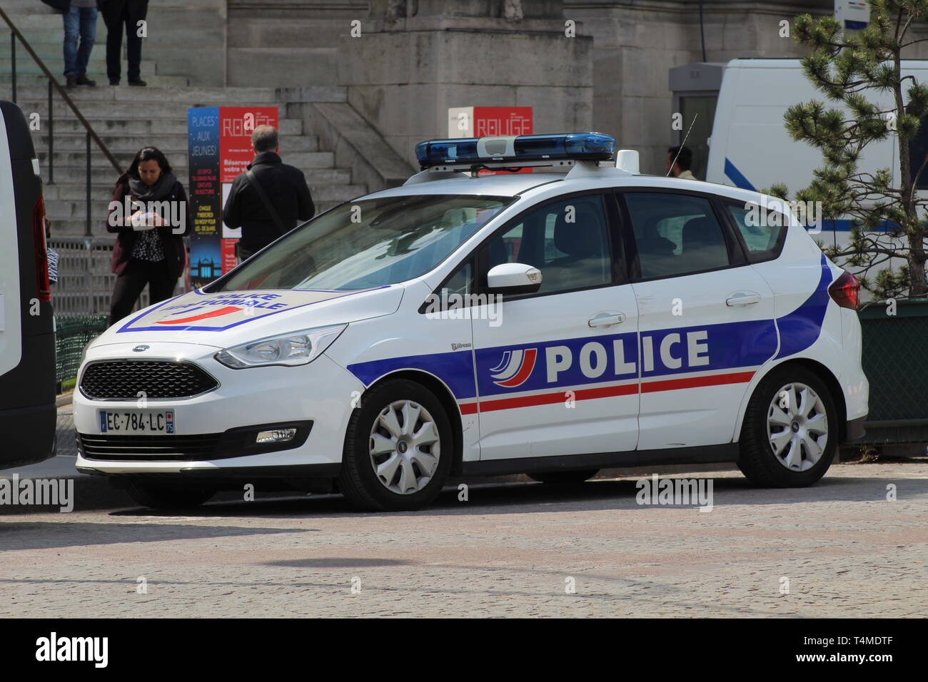 Une voiture de police se trouve dans l'ensoleillement en attente de son bureau pour retourner dans le centre de Paris. Banque D'Images