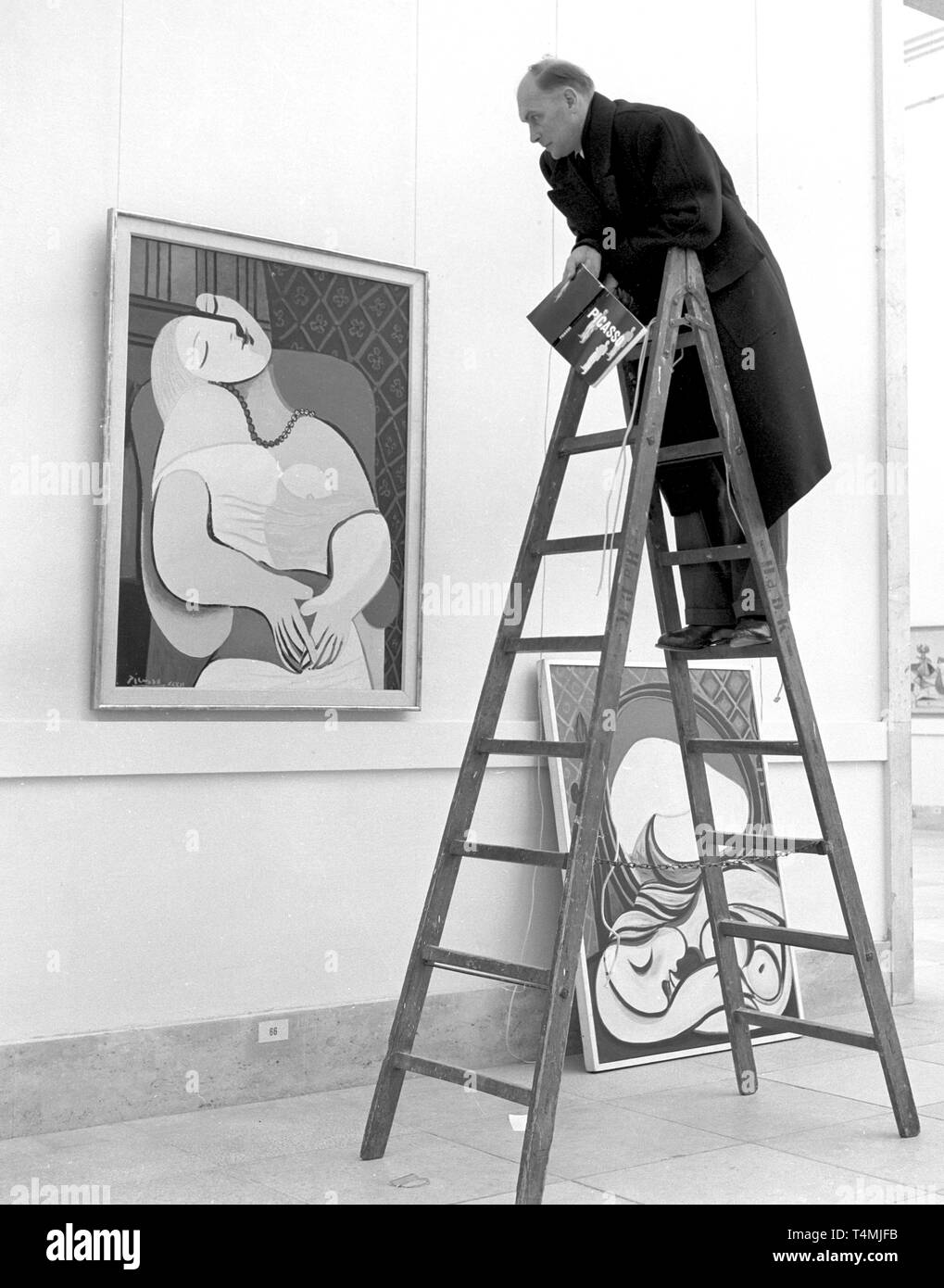 Un visiteur se dresse sur une échelle pour observer les painitng 'Le Rêve (le rêve)' à partir de 1932 dans l'exposition, qui sera présentée pendant deux mois sous le thème "rétrospective Picasso'. L'exposition includeds 250 ouvrages de le peintre espagnol Pablo Picasso, qui célèbre son 74e anniversaire le jour de l'ouverture le 25 octobre 1955. Dans le monde d'utilisation | Banque D'Images