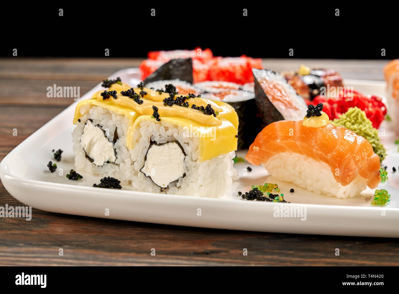 De délicieux petits pains au fromage avec du fromage à la crème, décoré de black caviar et de Mayo. Ensemble de sushi, maki nigiri sake, sake, wasabi et gingembre mariné. Banque D'Images