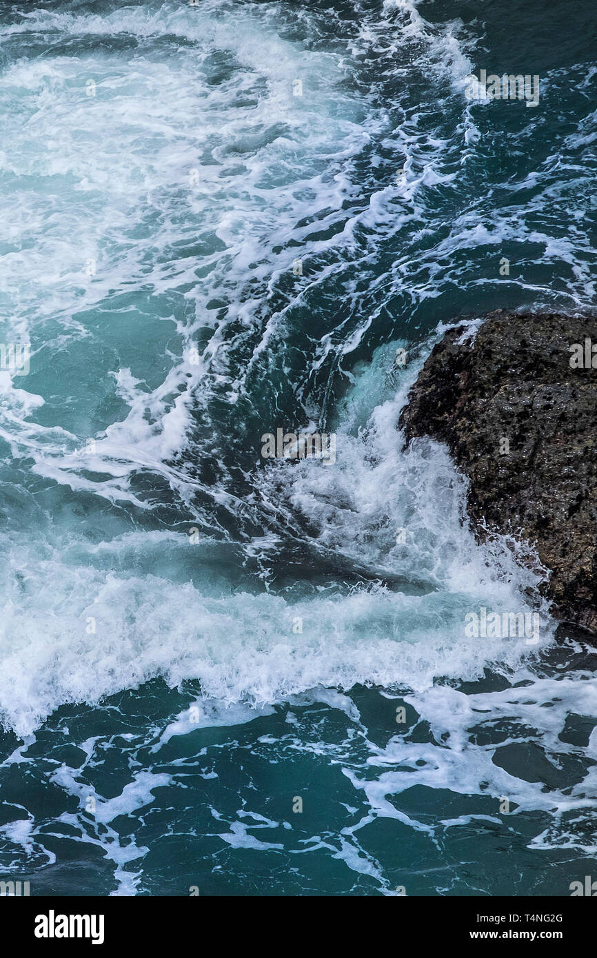 Tourbillonnant autour de la mer des rochers sur la côte de Cornwall, UK. Banque D'Images