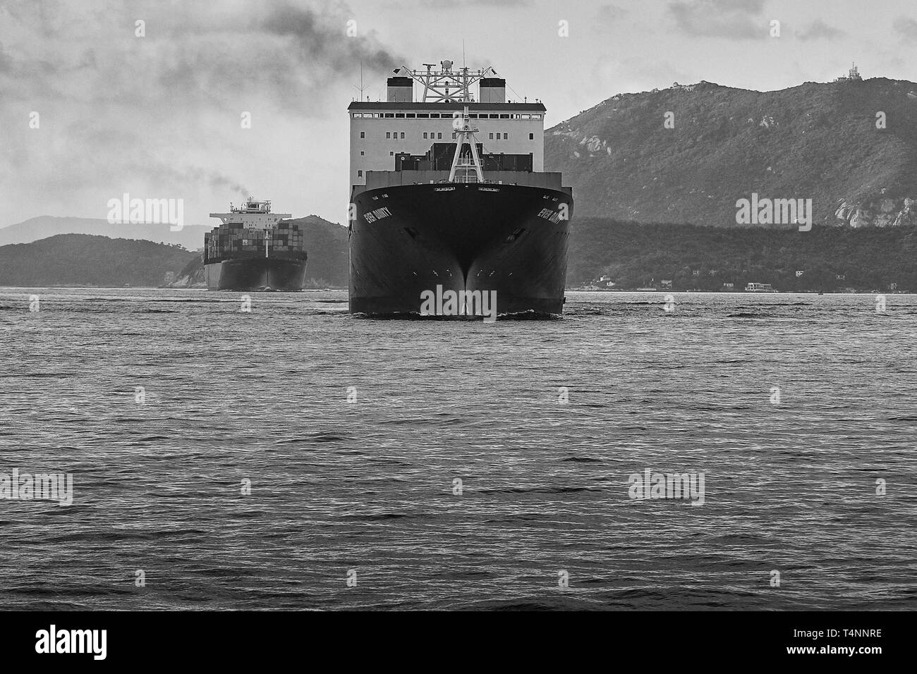 Photo frontale en noir et blanc de navires dans le chenal maritime occupé East Lamma, se dirigeant vers le terminal à conteneurs Kwai Tsing, Hong Kong, Chine Banque D'Images