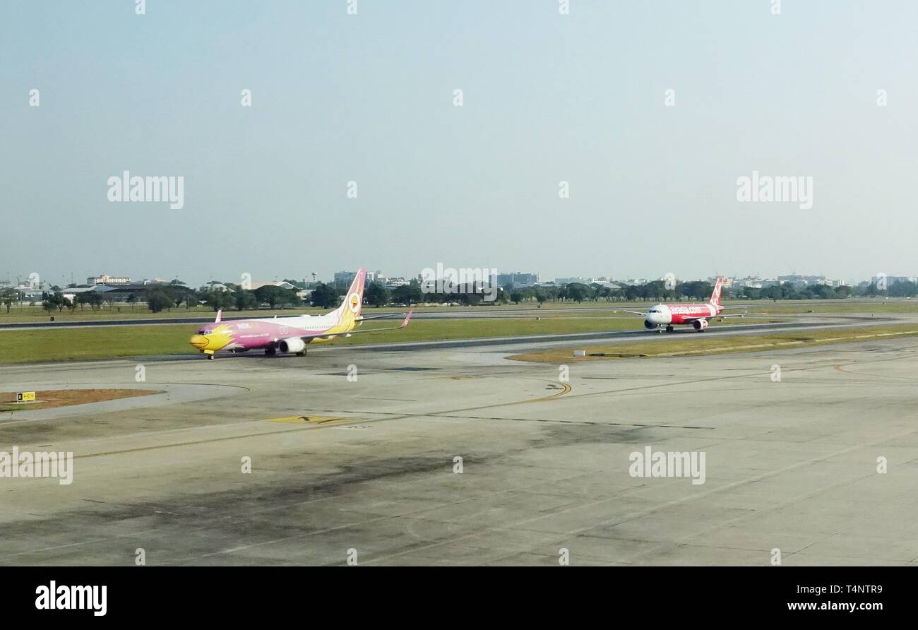 Les avions de Nok Air et AirAsia, 2 grandes compagnies aériennes à bas prix en Asie, sont successivement, sur une piste de l'aéroport, après leurs vols. Banque D'Images