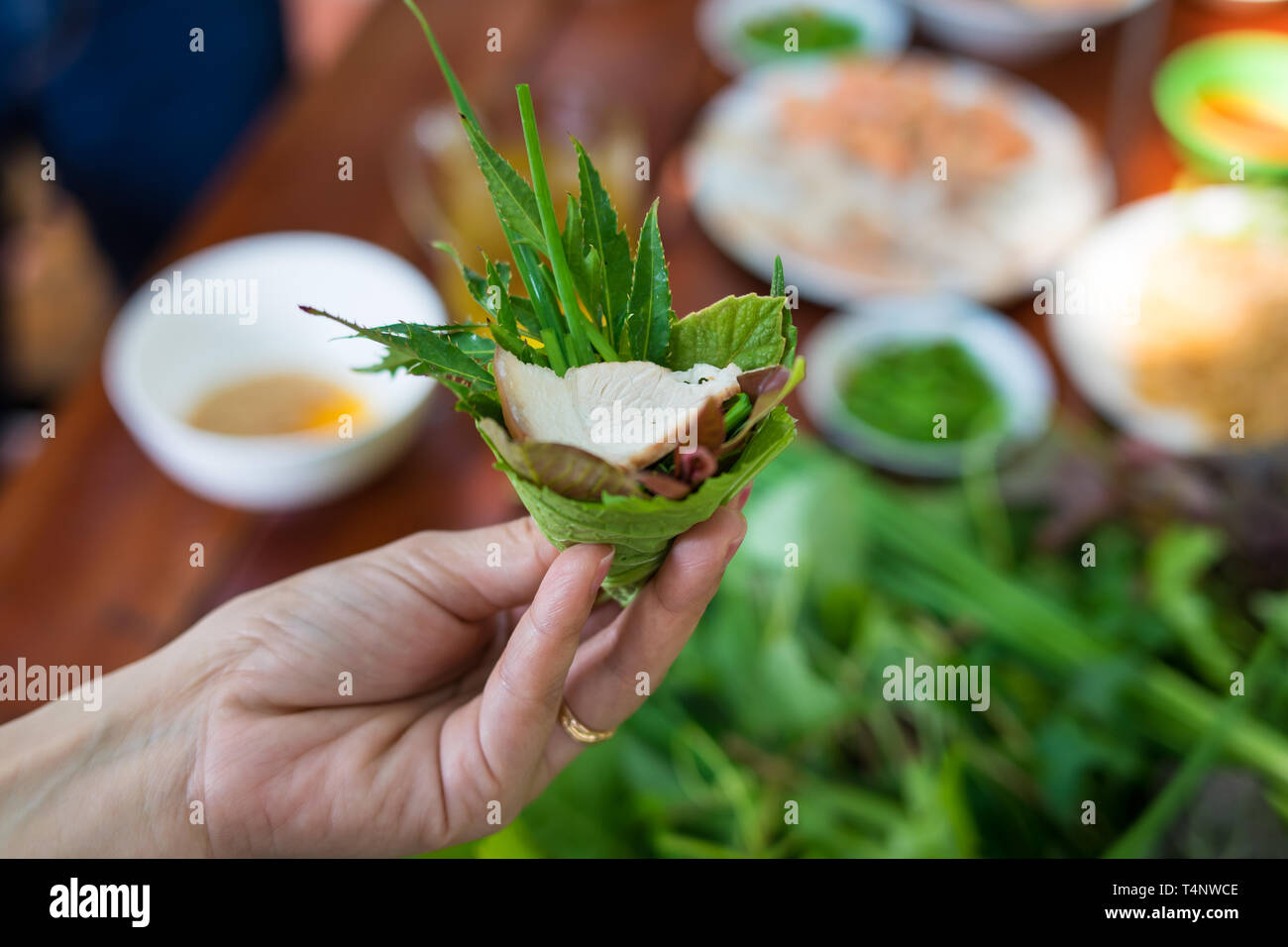 La salade d'herbe particulière à Kon Tum, Vietnam. En utilisant les feuilles pour faire un récipient en forme de cône pour mettre la nourriture et l'utilisation du bacon, crevettes frites, Coupe Banque D'Images