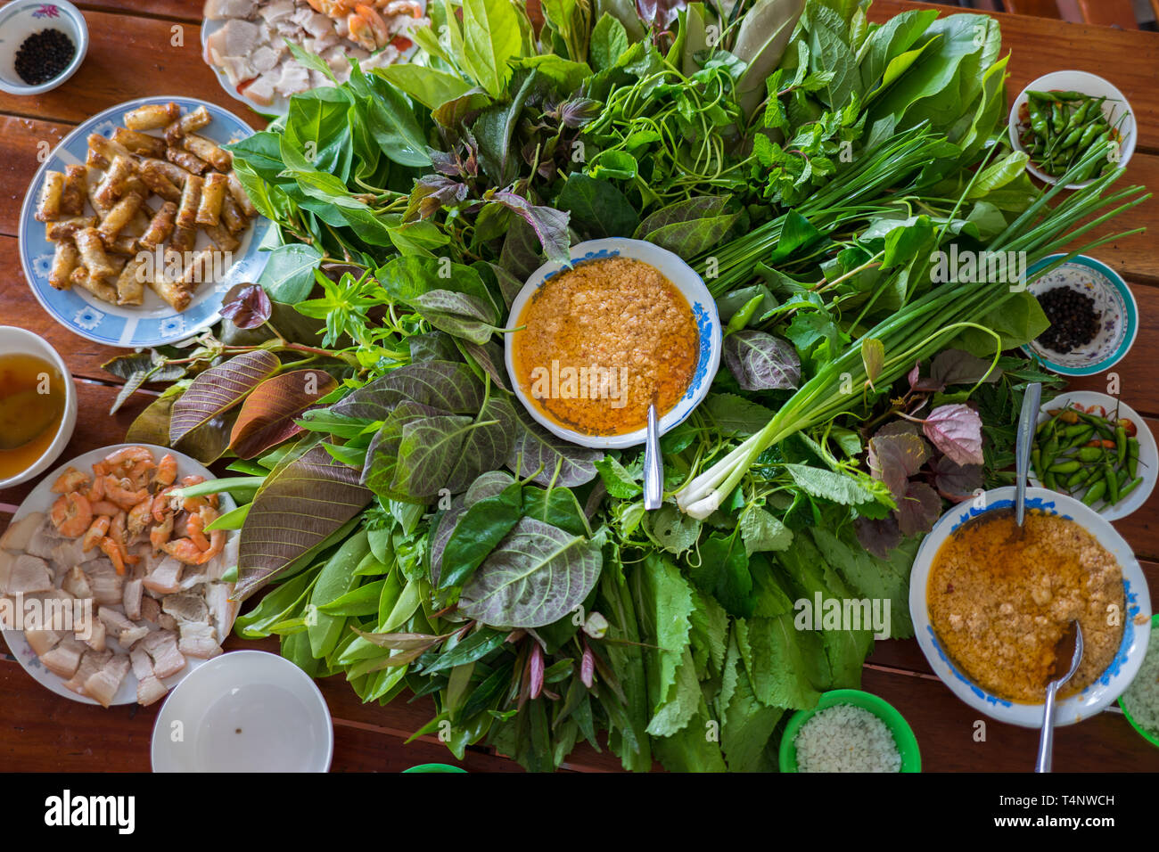 La salade d'herbe particulière à Kon Tum, Vietnam. En utilisant les feuilles pour faire un récipient en forme de cône pour mettre la nourriture et l'utilisation du bacon, crevettes frites, Coupe Banque D'Images