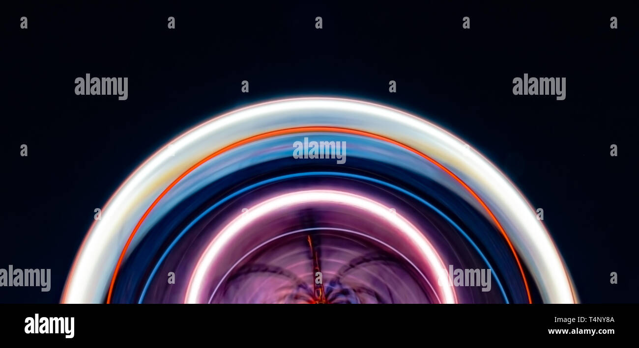 Belle et colorée de l'Arc de cercle Semi longue exposition d'une grande roue, tournant rapidement sur son axe. Banque D'Images