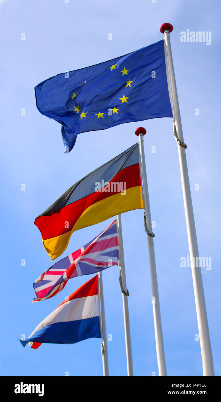 Les drapeaux de l'Angleterre, Royaume-Uni, Allemagne et Nederlands waving from mâts en coopération avec l'Europe, l'Union européenne, d'un drapeau contre un ciel bleu. Banque D'Images