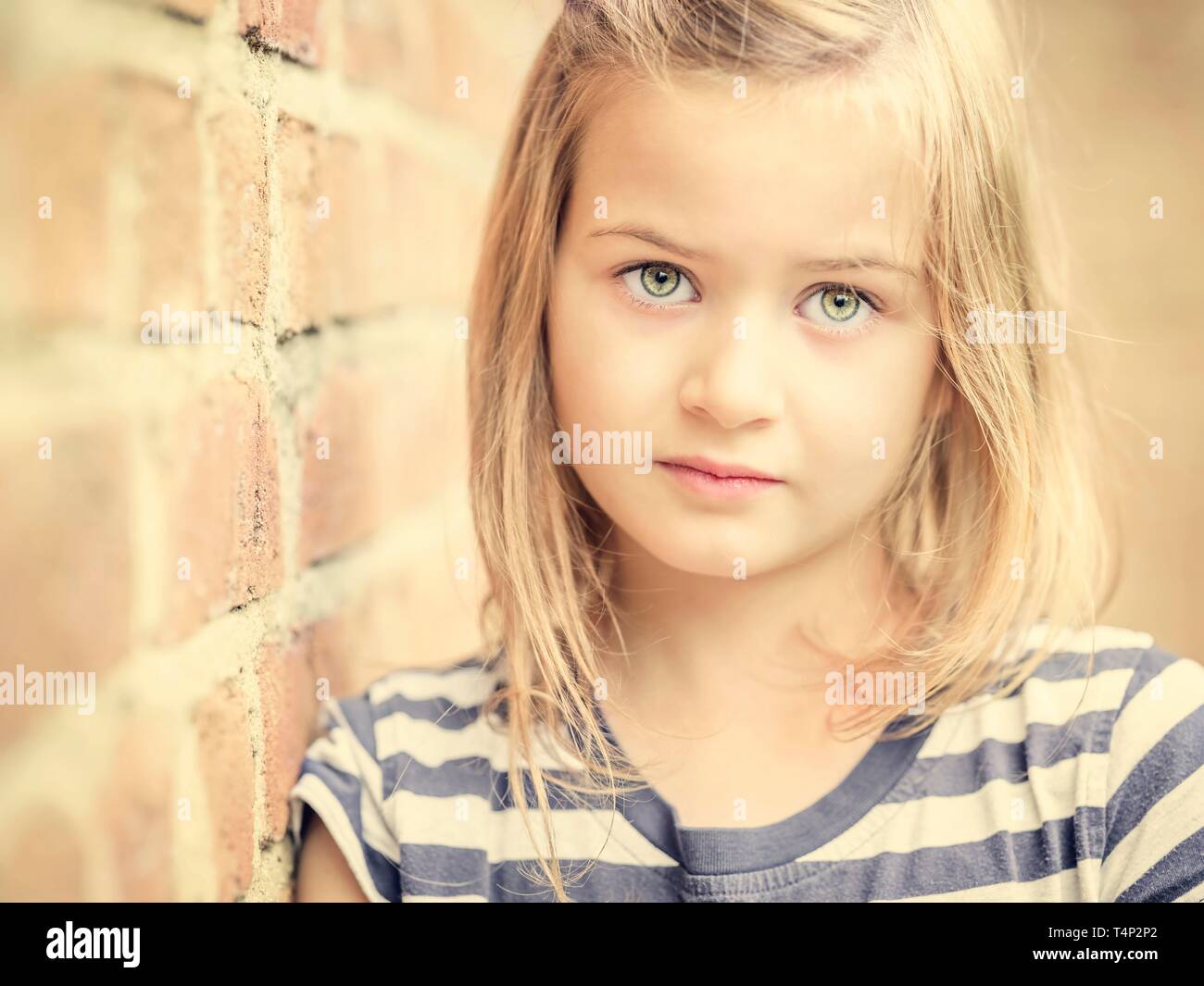 Fille, 10 ans, s'appuie contre un mur, vue directe, visage, portrait, Allemagne Banque D'Images