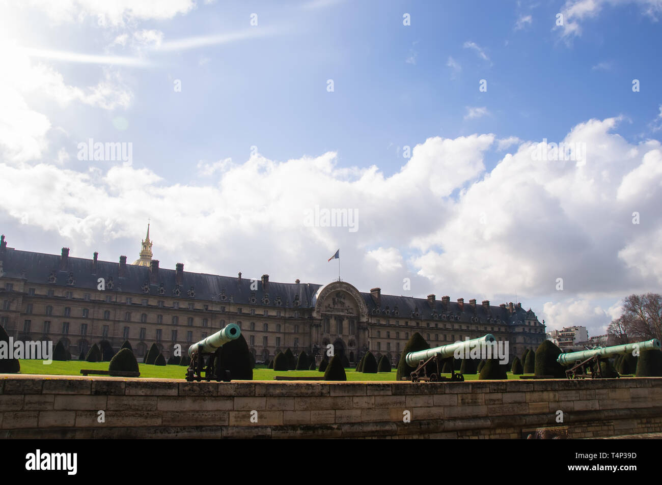 Vue sur le vieux canons en bronze sur le fond du Palais et le ciel bleu avec des nuages à Paris, France Banque D'Images