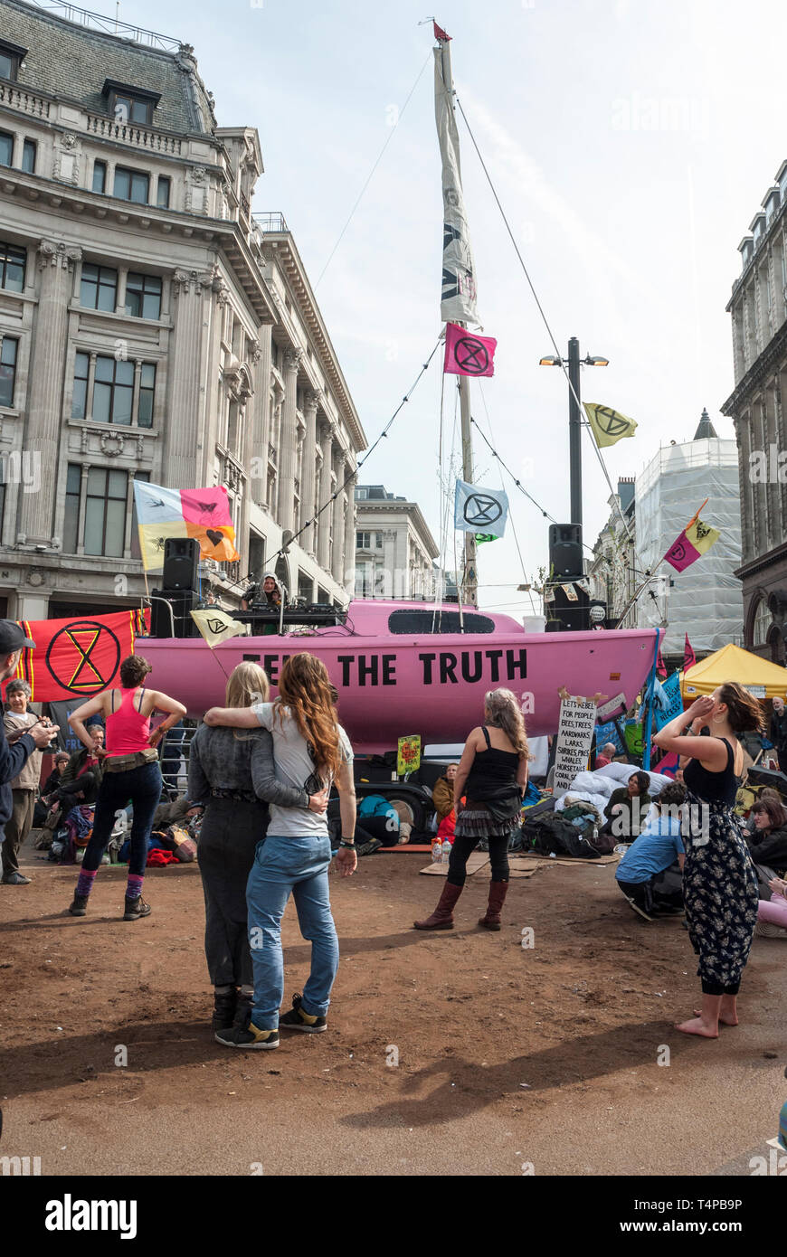 'Extinction, rébellion et embrasser la danse comme ils occupent ; derrière Oxford Circus est un yacht rose vif affichant un "Dire la vérité". Banque D'Images