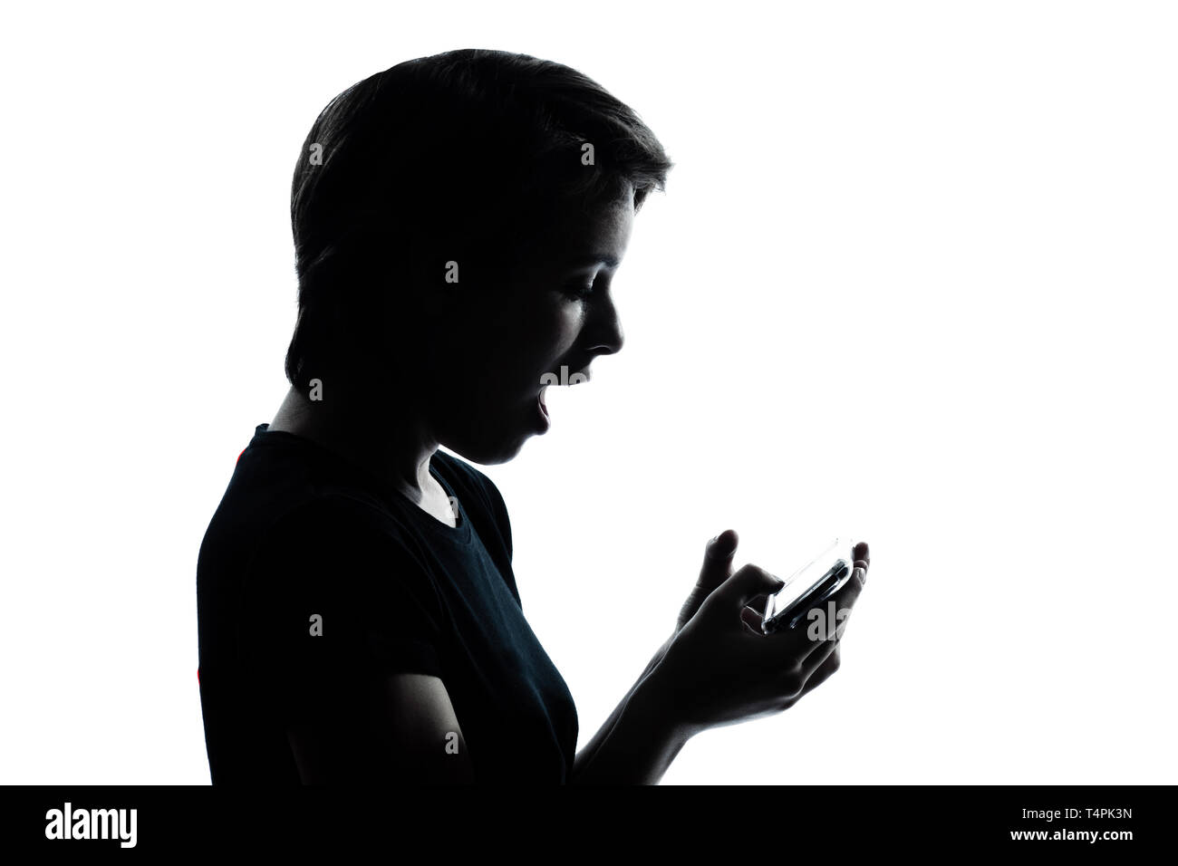 Portrait d'un jeune ado fille silhouette vidéophone téléphone jeu vidéo Portrait en studio cut out isolé sur fond blanc Banque D'Images