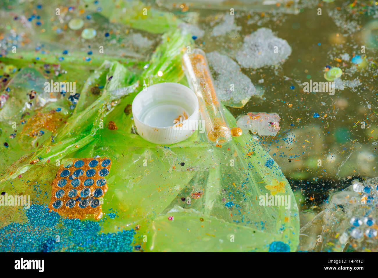 Pièces Glitter. Tas de sacs de plastique et les contenants flottant dans l'eau sale et visualisant l'état de nos océans Banque D'Images