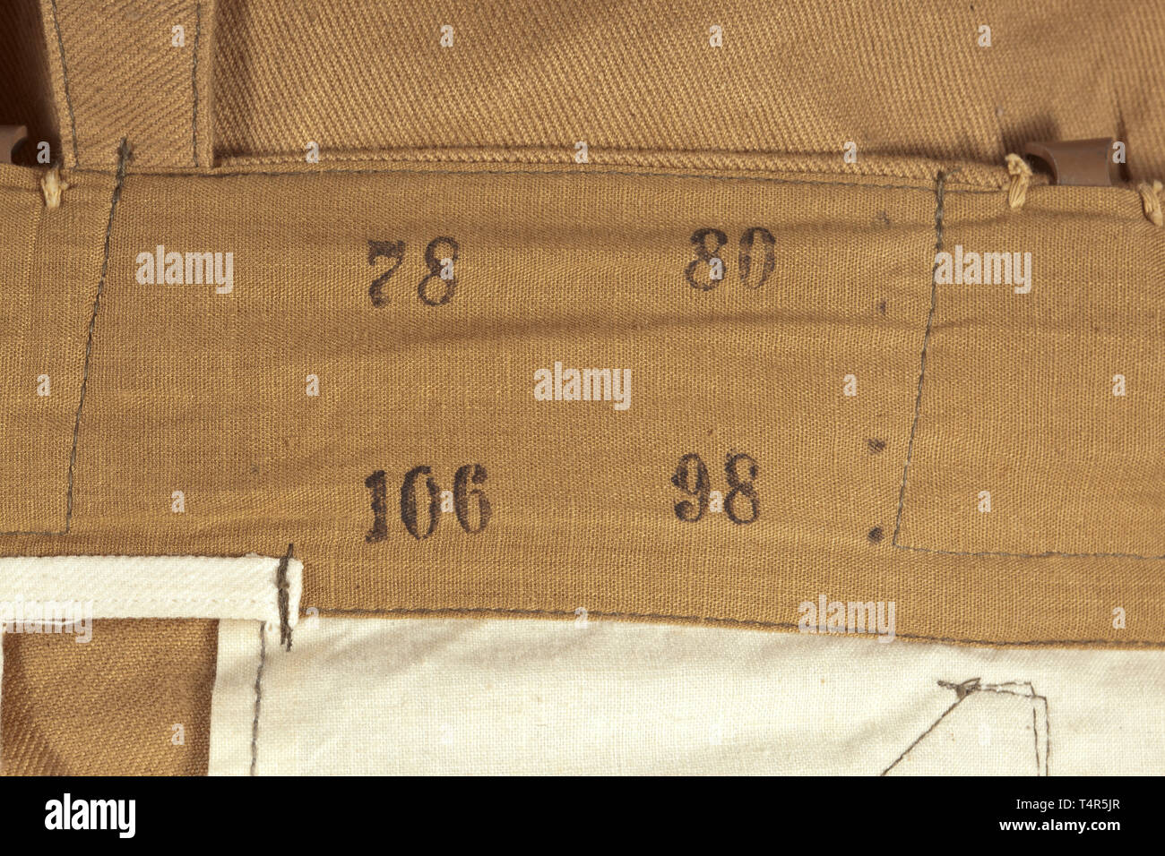 Une paire de 2ème modèle pantalon tropical pour la Waffen-SS depot pièce de couleur sable, coton sergé avec boutons de couleur brunâtre. La taille, avec cinq inversé, peint en brun et deux crochets de transport ceinture bretelles bretelles marche arrière pour fixation. Couverts fly, Incorporated, poche porte-oblique deux poches devant et deux poches de hanche droite chacun d'un bouton de fermeture. La borne de la jambe en forme de coin avec insewn les bandes de traction. Sacs de poche en coton blanc, la lumière de coton de couleur sable, avec la taille de l'estampage. Les traînées de marche arrière, sinon la couleur-frais et jamais utilisée., historique, historique du 20e siècle, Editorial-Use-seulement Banque D'Images