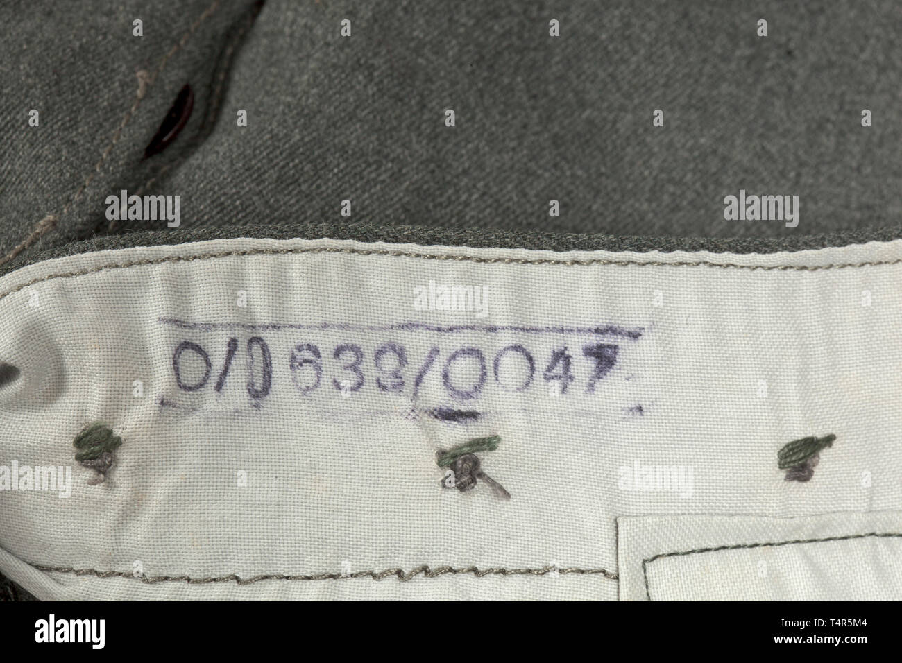 Une paire de pantalons champ M 43 pour le personnel de l'armée depot morceau avec Reich numéro d'usine de production domaine-gris gabardine italien (ouvert) avec les boutons en verre brun. Soulevé d'usure arrière avec bretelles, deux des quatre larges passants utilisable pour la fixation des bretelles, couverts voler avec renfort de soie brunâtre. La poche à rabat de fermeture fob, l'oblique intégrée poches devant et poche arrière droite chaque bouton avec fermetures. Les bornes de la jambe avec chute et de maintien. Chemise en coton léger avec RB Nombre et taille de l'estampillage des vêtements de Francfort, Editorial-Use-seulement o Banque D'Images