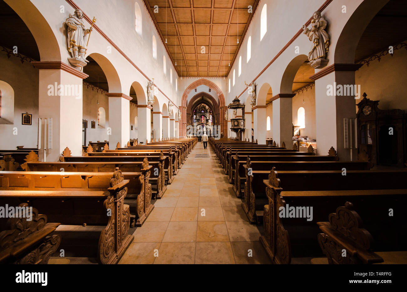 Hanau, Allemagne. 18 avr, 2019. Un homme marche dans la nef de l'église de Saint Marcellin et Saint Pierre. L'église a été construit à partir du 9e siècle pour le monastère bénédictin, qui a été fondée en même temps. Le constructeur était Eginhard, biographe de Charlemagne. Crédit : Andreas Arnold/dpa/Alamy Live News Banque D'Images