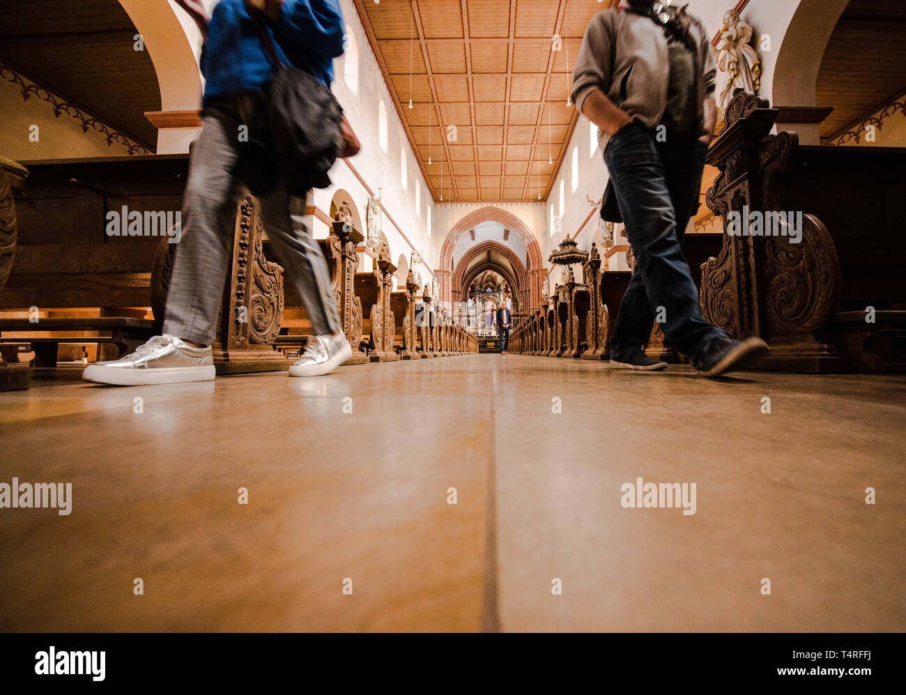 Hanau, Allemagne. 18 avr, 2019. Deux personnes marcher dans la nef de l'église de Saint Marcellin et Saint Pierre. L'église a été construit à partir du 9e siècle pour le monastère bénédictin, qui a été fondée en même temps. Le constructeur était Eginhard, biographe de Charlemagne. Crédit : Andreas Arnold/dpa/Alamy Live News Banque D'Images