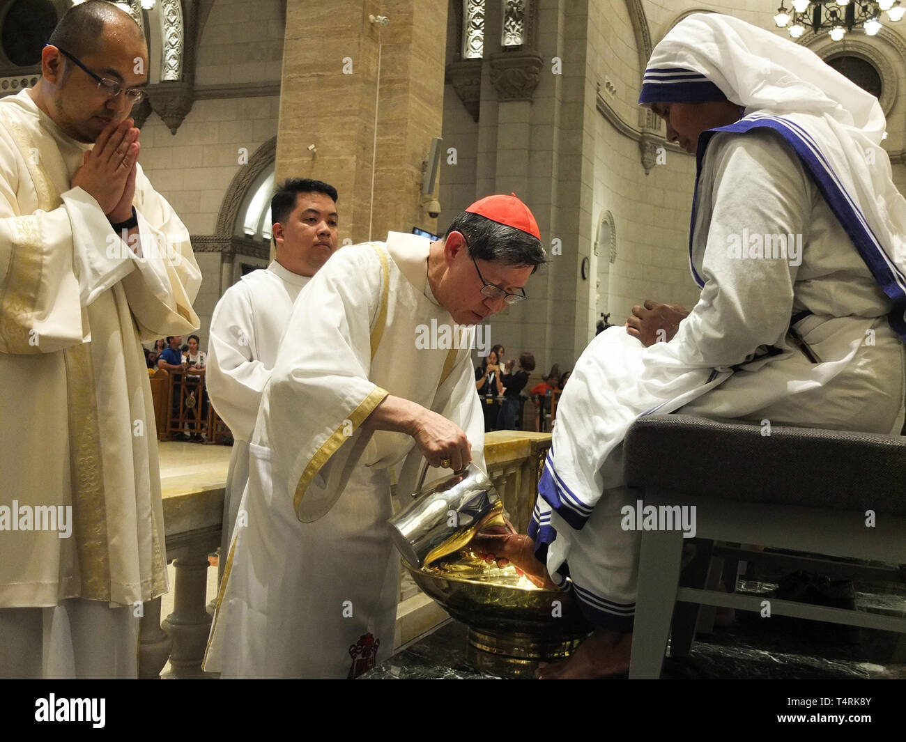 Le Cardinal Archevêque de Manille Luis Antonio Tagle vu le lavage des pieds de Soeur Antonisa, une religieuse des Missionnaires de la charité pendant la procession. Lavage des pieds est un droit religieux observé par les catholiques, c'est une forme de commandement de Jésus Christ que nous devrions imiter son humilité d'amour alors que l'archevêque de Manille, le Cardinal Luis Antonio Tagle lave les pieds des douze jeunes pendant le Jeudi Saint au service religieux dans la Cathédrale de Manille Manille. Banque D'Images