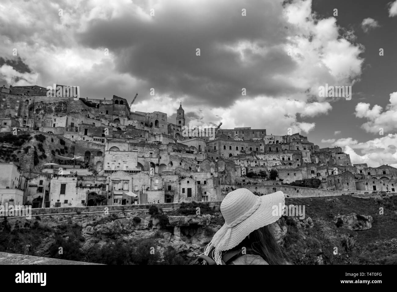 Voir jour d'été de l'ancienne ville de la Sassi avec blanc nuages gonflés déménagement sur ciel bleu italien. Matera, Basilicate, Italie. Jeune femme pour Banque D'Images