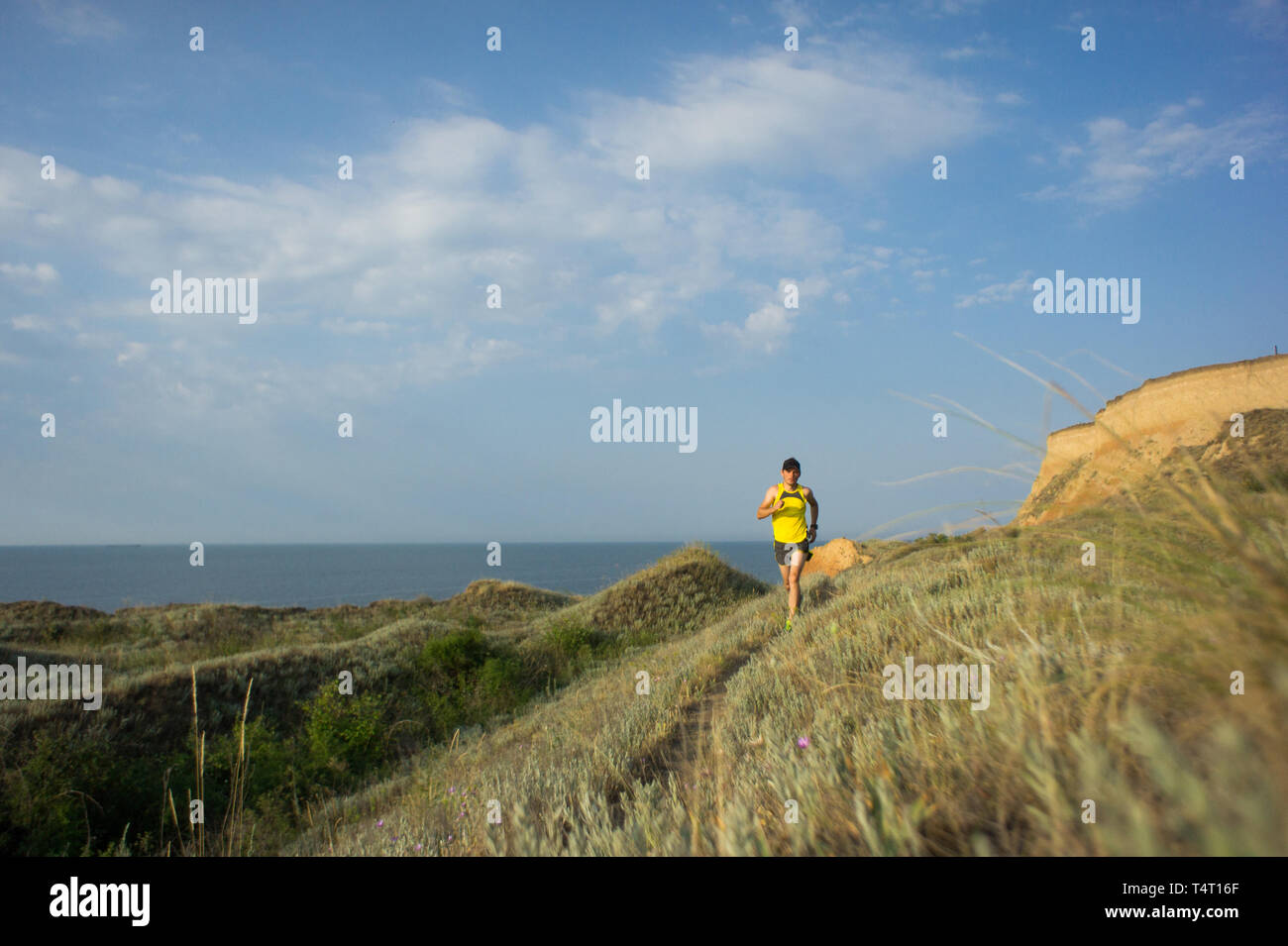 Sport running man in cross country trail run. Runner mâle l'entraînement à l'exercice et le saut à l'extérieur dans une vue magnifique sur la montagne nature paysage Banque D'Images