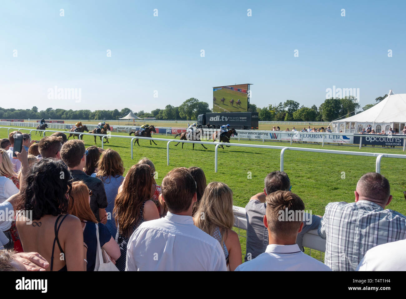 La foule regarde la fin d'une course de chevaux à l'Hippodrome Royal Windsor, Windsor, Royaume-Uni. Banque D'Images