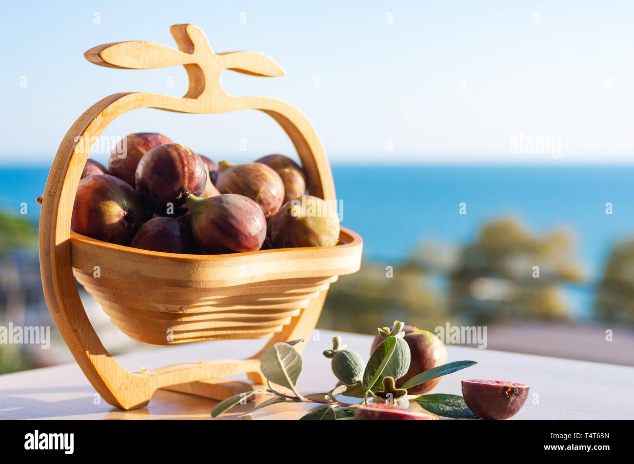 Figues fraîches. Fig de fruits dans un vase en bois contre le fond de la mer. La récolte d'été. Espace libre pour le texte Banque D'Images