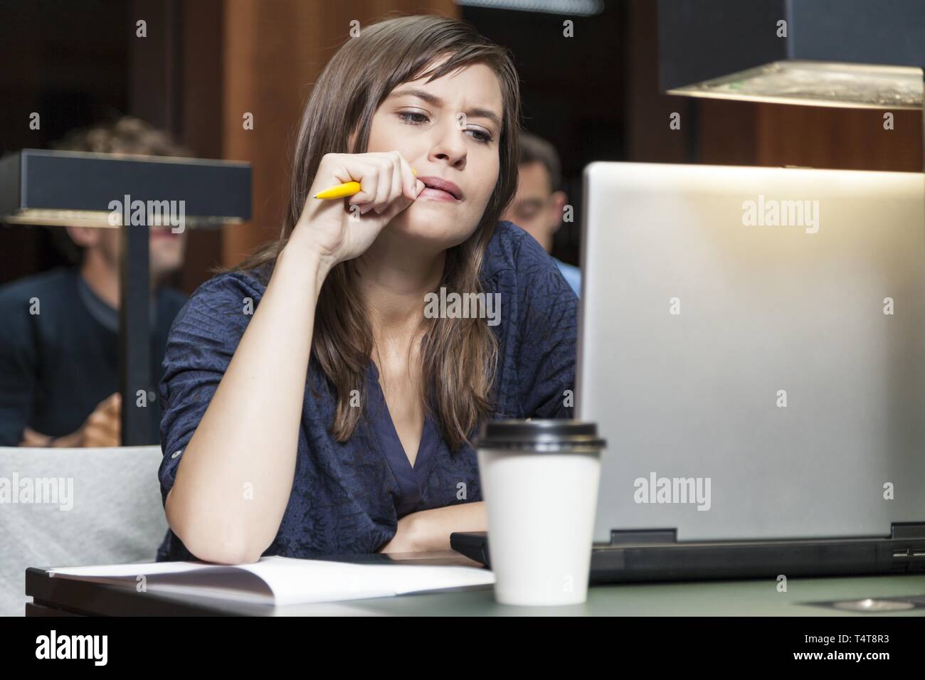Student working on laptop in library Banque D'Images