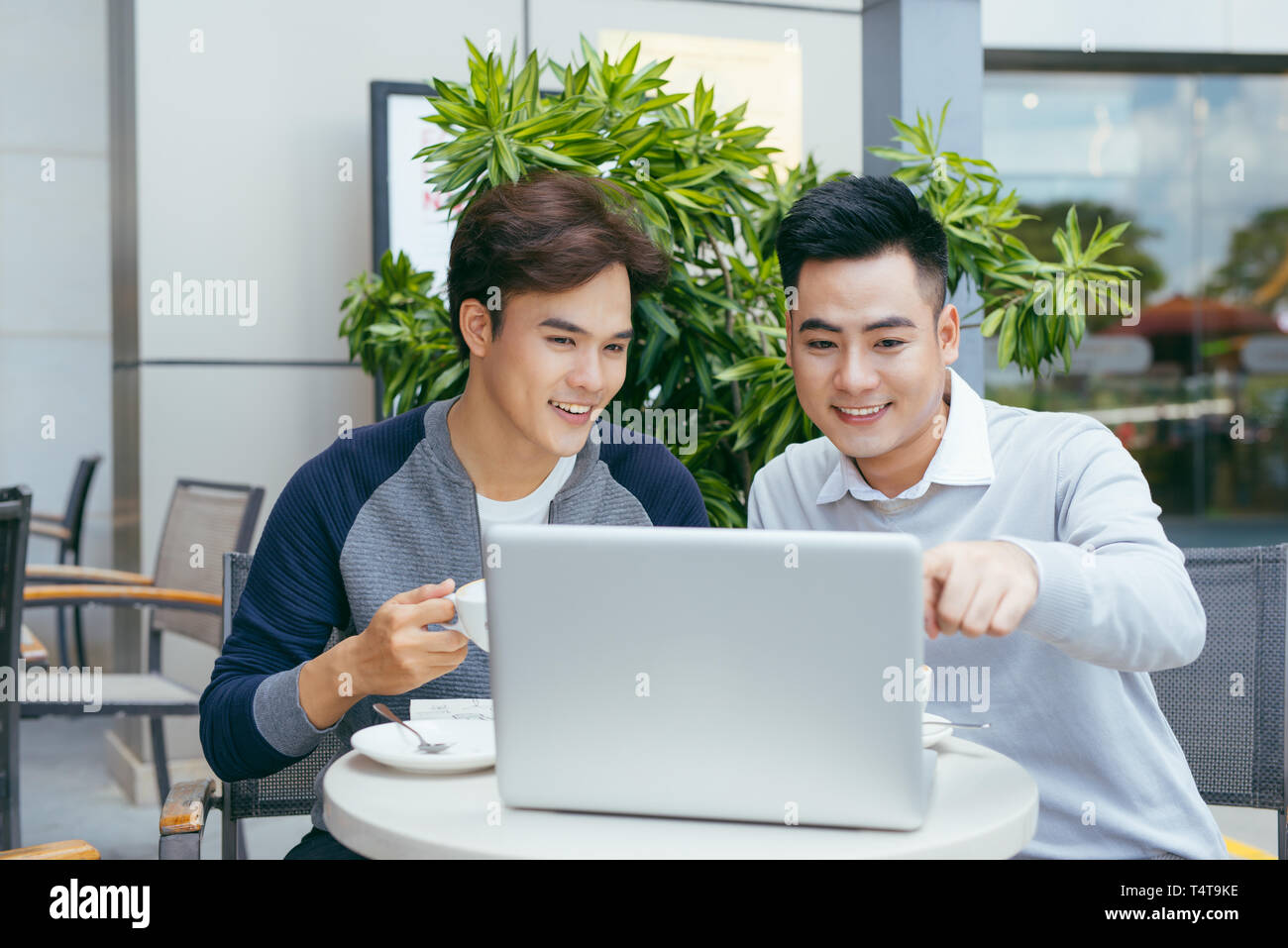 Les gens d'affaires à la recherche de document et discuter tout en café. Deux hommes d'affaires travaillent ensemble à business report du coffee shop. - Image Banque D'Images