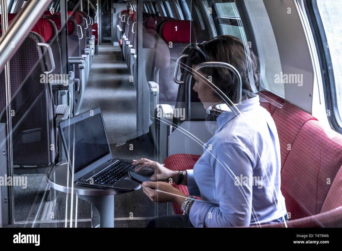 Business woman en train de première classe, le travail avec ordinateur portable et téléphone mobile, Suisse Banque D'Images