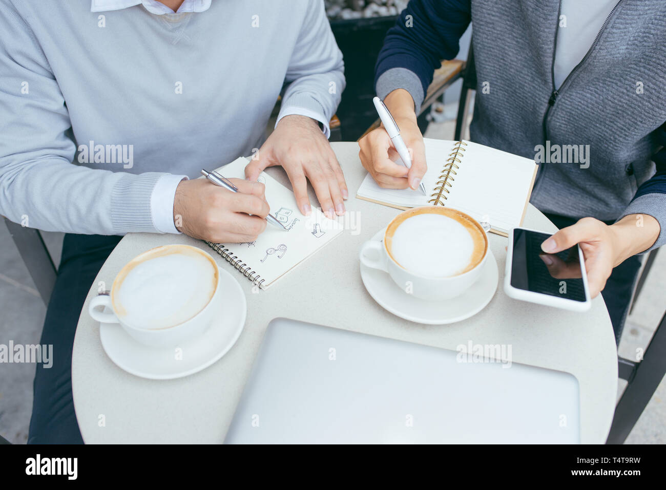 Deux jeunes hommes sont en pleine discussion dans un café. - Image Banque D'Images