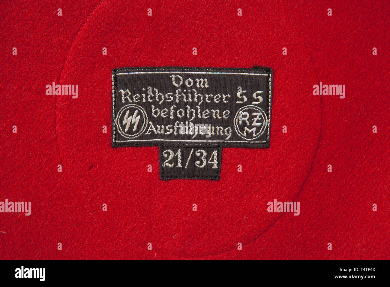 La COLLECTION JOHN PEPERA, un SS-Brassard, construction multi-pièces, de laine rouge, champ de base avec 8,5 cm de diamètre, central, nervuré verticalement, teinté blanc rayonne, champ circulaire avec un montage incliné, côtelés, ruban rayonne noir croix gammée. Les bords supérieur et inférieur de la bordée brassard avec 8 mm de large striée verticalement, rayonne noir bande. Complet avec brassard 'noir Reichsführer SS befohlene Ausführung mit RZM SS' '21/34' tag chiffon. Dommages de 12 mm le long du bord supérieur de l'inverse de la dépose. tunique, Editorial-Use-seulement Banque D'Images