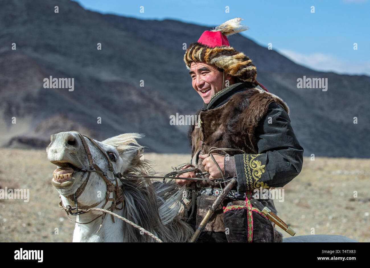 Bayan Ulgii, Mongolie, 3 octobre 2015 : kazakh man in traditional pardessus et chapeau avec son aigle sur un cheval Banque D'Images