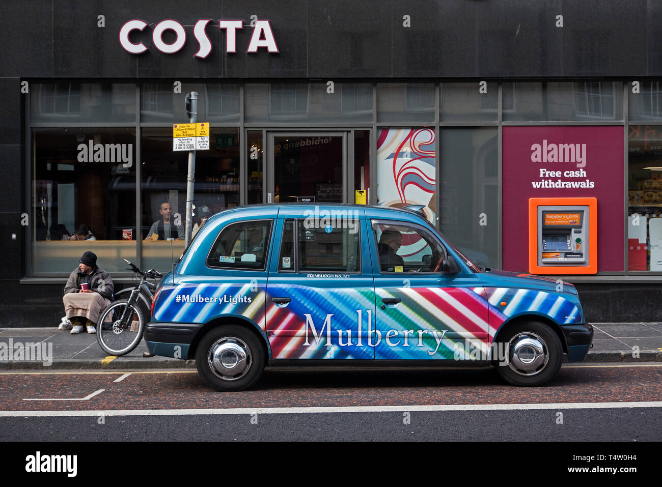 Un mendiant, taxi et ATM sur South Bridge Edinburgh, Ecosse, Royaume-Uni. Banque D'Images