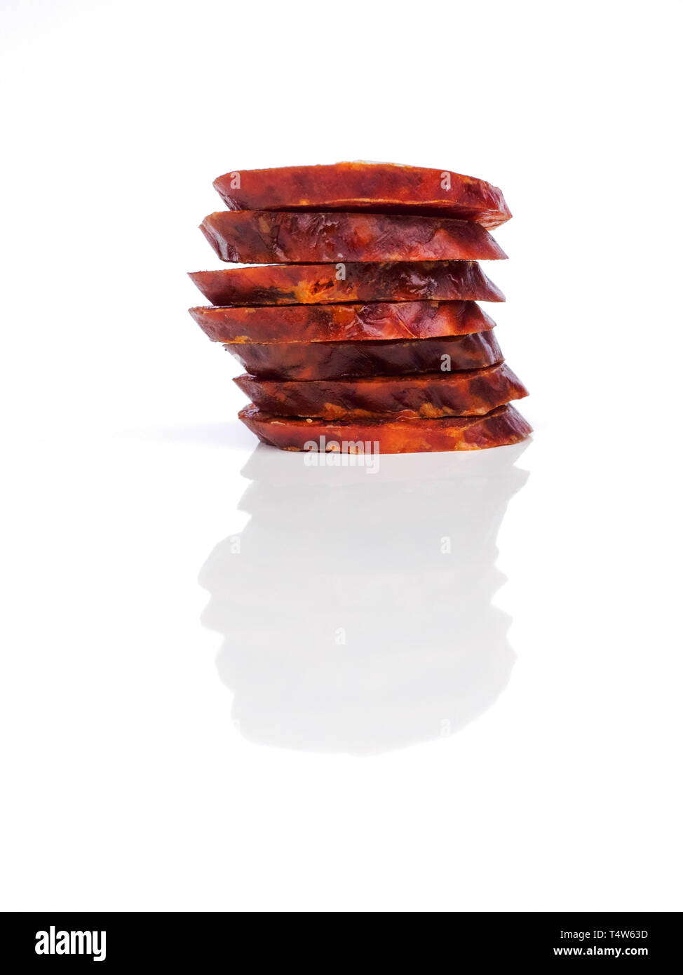 Chorizo ibérique, ​​Or la saucisse chorizo espagnol espagnol couper en rondelles placées l'une sur l'autre sur un fond blanc, typique espagnol tapa Banque D'Images
