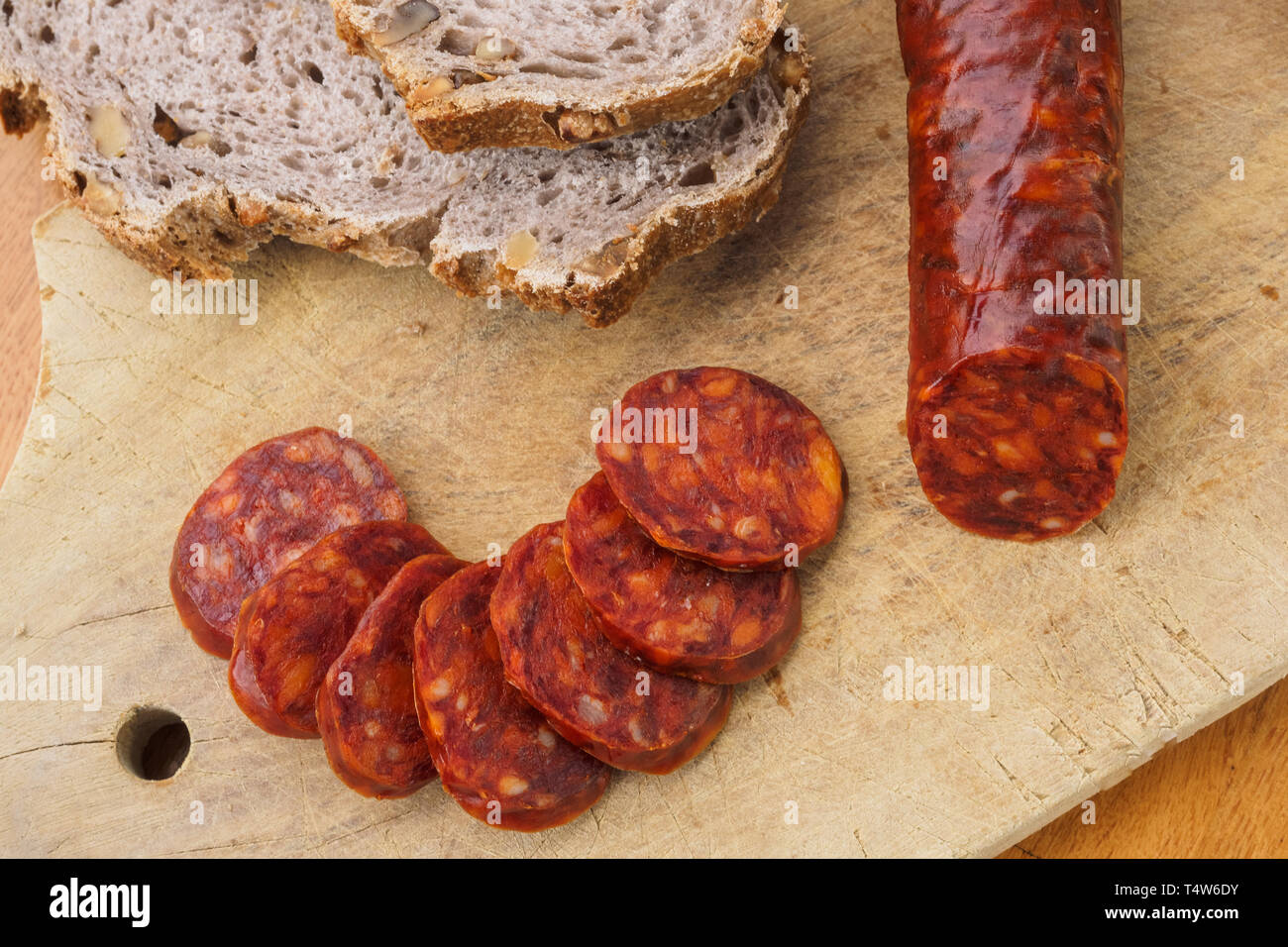 Chorizo ibérique, ​​Or la saucisse chorizo espagnol espagnol coupé en tranches sur une planche en bois avec pain rustique Banque D'Images