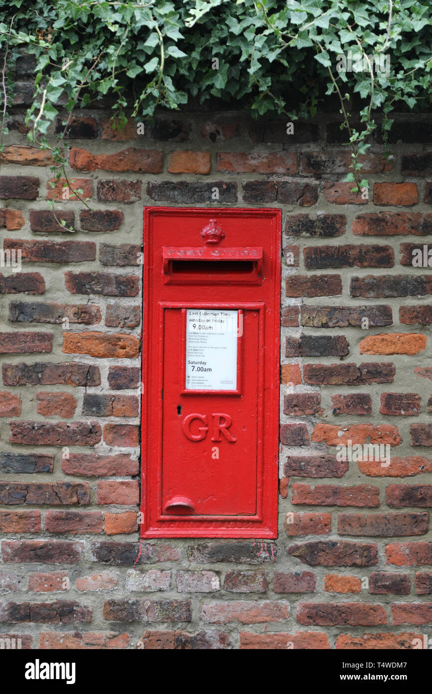 Un 'George Rex' ou 'GR' British Post Office post box set dans le mur de brique du Beverley Minster ancien presbytère à Beverley, East Riding. Banque D'Images