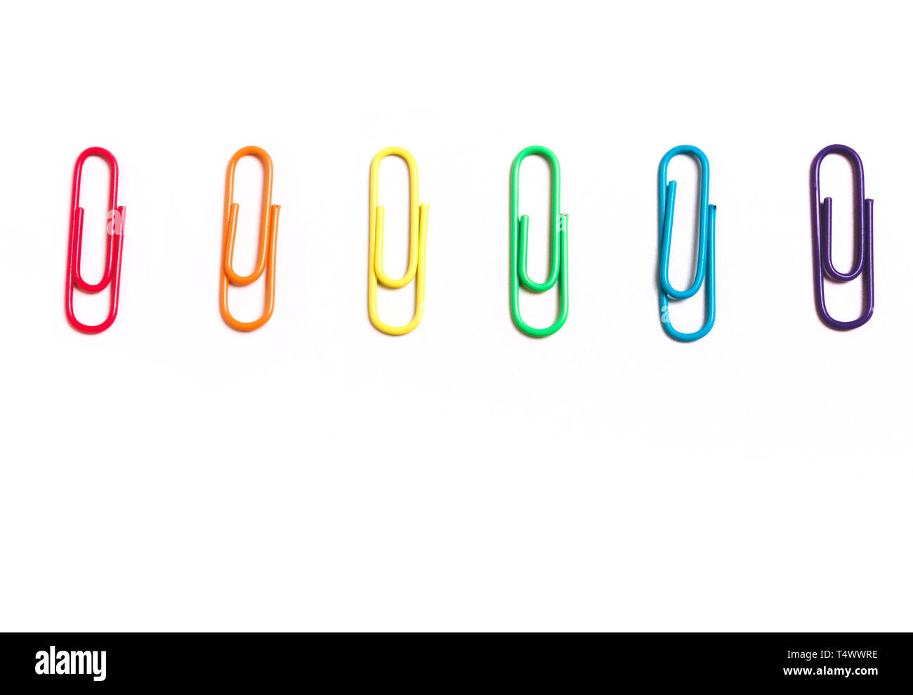 Papeterie trombones couleurs de l'arc-en-ciel sur un fond blanc. Symbole, drapeau LGBT Banque D'Images