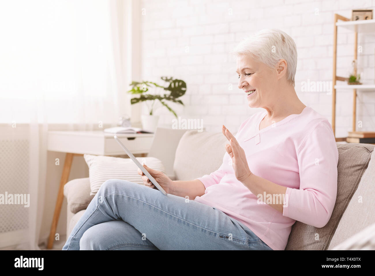 Happy senior femme parler avec vos proches via digital tablet Banque D'Images