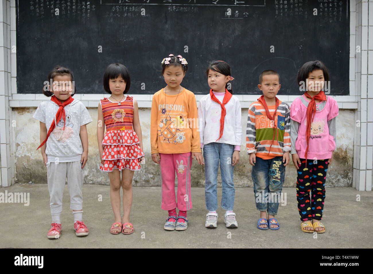 L'âge des enfants de l'école primaire s'alignent pour une photo dans la cour de l'école en milieu rural de la région de Guangxi, dans le sud de la Chine centrale. Banque D'Images