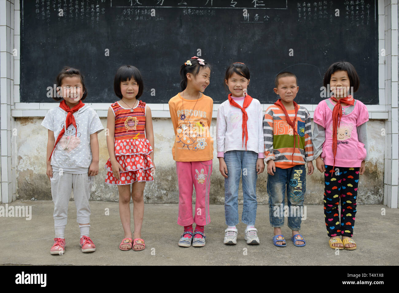 L'âge des enfants de l'école primaire s'alignent pour une photo dans la cour de l'école en milieu rural de la région de Guangxi, dans le sud de la Chine centrale. Banque D'Images